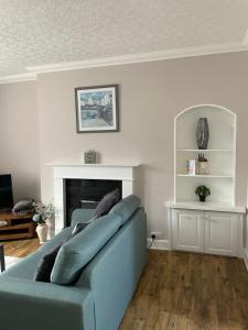 a blue couch in a living room with a fireplace at Albert Road Apartment in Eyemouth