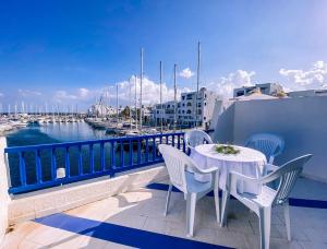 een tafel en stoelen op een balkon met een jachthaven bij Marina Cap Monastir- Appart'Hôtel in Monastir