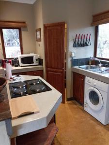uma cozinha com um fogão e uma máquina de lavar roupa em 11 Raptors Lodge em Hoedspruit