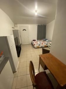 a kitchen with a table and a chair in a room at Charming 1-Bed Apartment 20 mins to Paris by train in Goussainville