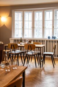 a restaurant with wooden tables and chairs and windows at Nineofive Hotel in Jena