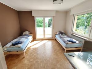 - 2 lits dans une chambre avec 2 fenêtres dans l'établissement Schaefer Apartments - Villa Bischof, à Offenbach-sur-le-Main