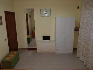een woonkamer met een witte kast en een tv bij Top bedroom GOLFO - Le Lincelle, Lamezia - 2 extra large single beds in SantʼEufemia Lamezia