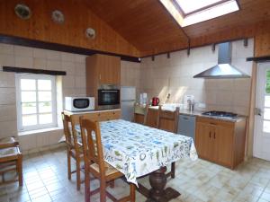 a kitchen with a table and chairs and a kitchen with a table and a kitchen at Domaine de Pratulo in Cléden-Poher