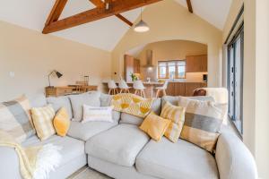 una sala de estar con un sofá blanco con almohadas en Swifts Retreat, en Bidford