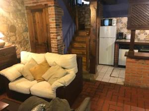 un sofá en una habitación con cocina en La Regenta Picos de Europa, en Poo de Cabrales