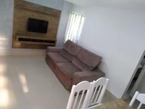 - un salon avec un canapé et une télévision dans l'établissement LA15-Bertioga, Próximo ao SESC, Riviera, Vista Linda, Indaiá, à Bertioga