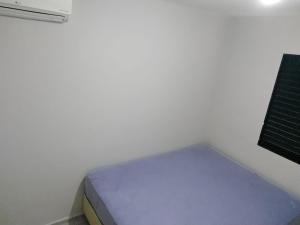 - un petit lit dans une chambre à côté d'un mur dans l'établissement LA15-Bertioga, Próximo ao SESC, Riviera, Vista Linda, Indaiá, à Bertioga