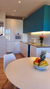 a kitchen with a table with a bowl of fruit on it at Beautiful view apartment with garage space in Mali Lošinj