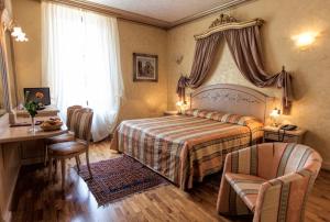 a bedroom with a bed and a table and chairs at Hotel Colomba d'Oro in Verona