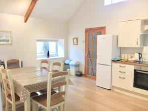 eine Küche und ein Esszimmer mit einem Tisch und Stühlen in der Unterkunft Cosy Cottages in Llandeilo