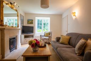 a living room with a couch and a fireplace at Temple Guiting Cottage in Temple Guiting