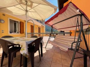 a patio with a table and an umbrella at Appartamento Capri in Arco