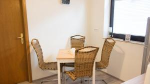 a dining room with wicker chairs and a table at Ferienwohnung Sören in Nahrendorf