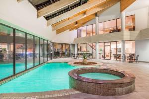 an indoor swimming pool in a house with glass windows at Wyndham Virginia Beach Oceanfront in Virginia Beach