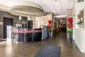 a lobby of a hotel with a reception counter and flowers at Econolodge Inn & Suites St-Apollinaire in Saint-Apollinaire