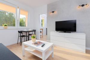 a living room with a tv and a white dresser at Jagiellońska Apartments Przymorze Beach by Renters in Gdańsk