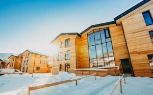a building with snow in front of it at Kreischberg Suites by ALPS RESORTS in Sankt Lorenzen ob Murau