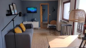 a living room with a couch and a tv at Hochwald-Balkon in Bad Sachsa