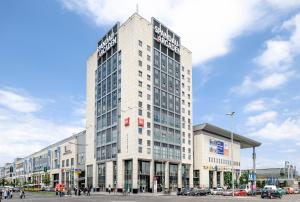 Ein hohes weißes Gebäude mit einem Schild drauf. in der Unterkunft ibis Hotel Berlin Spandau in Berlin