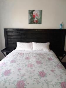 um quarto com uma cama com colcha floral em 2 Bedroom Residential Home, along the coast. em Durban