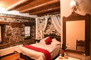 a bedroom with a bed and a large mirror at Archontiko Tarsouna in Palaios Agios Athanasios