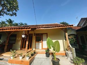 a house with potted plants in front of it at Sadewa homestay batukaras in Batukaras
