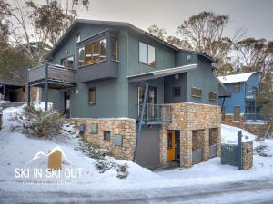 a house in the snow with the words six in six out at On The Snow 1 in Thredbo