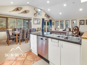 a kitchen with a sink and a dining room at On The Snow 1 in Thredbo