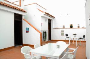 a white table and white chairs in a room at Banana Surf House in Los Cristianos