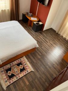 Habitación con cama y alfombra en el suelo en Vila Casa Ta, en Sinaia