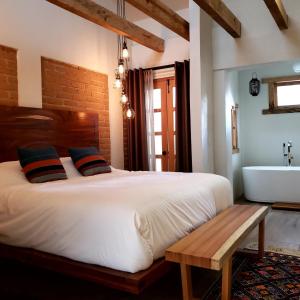 una camera con un grande letto e una vasca da bagno di Casa Carmen a San Cristóbal de Las Casas