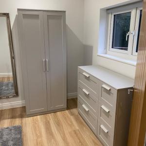 a bedroom with a dresser and a window at Haven Oaks - Self contained rural lodge 2 in Shedfield