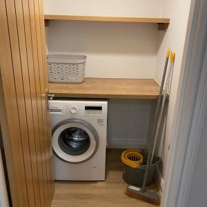 a laundry room with a washing machine and a shelf at Haven Oaks - Self contained rural lodge 2 in Shedfield