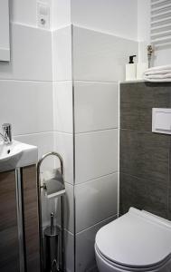 a white bathroom with a toilet and a sink at Löwen Hotel in Radevormwald