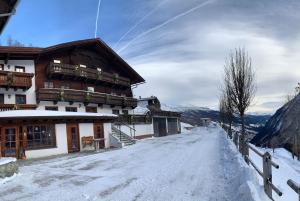 a snow covered road in front of a building at Ferienhof-Oberer-Gollmitzer-2-5-km-oberhalb-von-Heiligenblut-ruhige-sonnige-Lage-Glocknerblick in Heiligenblut