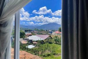 a view of a city from a window at Wisma Maestro Toraja Mitra RedDoorz in Rantepao +29 photos