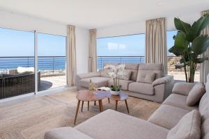 ein Wohnzimmer mit einem Sofa und einem Tisch in der Unterkunft Luxury Villa María private heated pool in Adeje