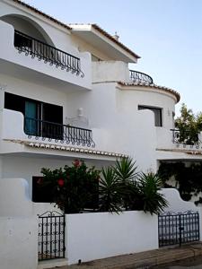 a white building with balconies and plants in front of it at Casa Vista Mar in Luz