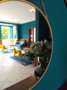 a mirror with a vase of flowers in a room at Hôtel de la Marine in Saint-Herblain