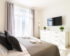 ein Schlafzimmer mit einem Bett mit zwei Handtüchern darauf in der Unterkunft Baltic Home in Świnoujście