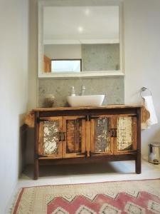 een badkamer met een wastafel en een spiegel bij Louvre Guesthouse in Bothaville