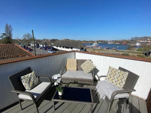 a patio with two chairs and a table on a deck at Swan View, Oulton Broad in Lowestoft