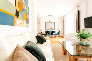 a living room with a white couch and a glass table at Minty Stay 3BD Apartment - Triana in Seville