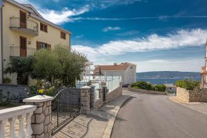 an empty street with a building and a fence at Apartments Villa Ivka in Crikvenica