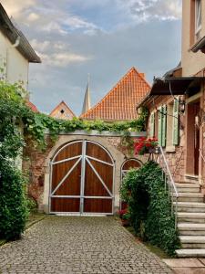 een garage met een grote houten deur op een huis bij Gästehaus Zum Weinbauer in Rhodt unter Rietburg