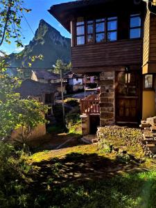 a wooden house with a mountain in the background at Casa de Ligueria in Rozapanera