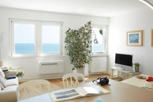 a white living room with a table and a plant at Maison del Bassotto in Numana