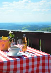 einen Tisch mit einer Flasche Wein und einem Teller Essen in der Unterkunft Gasthaus 3-Länderblick Mönichkirchen in Mönichkirchen