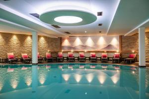 basen w pokoju hotelowym z krzesłami wokół niego w obiekcie Hotel Adapura Wagrain w mieście Wagrain